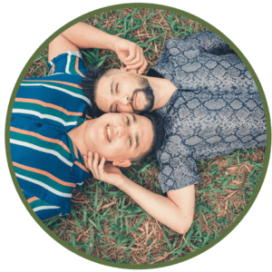 two men cuddling on grass lying down